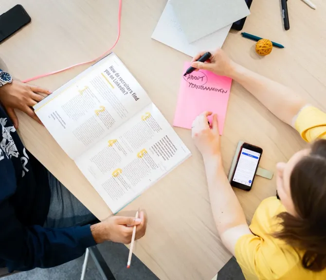 Kaksi henkilöä tarkastelee Työkirjan artikkelia LinkedInistä