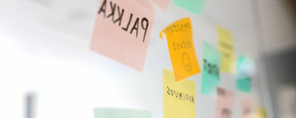 Post-it lappuja liimattuna neuvotteluhuoneen lasiseinään