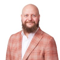 Kalle Airo, parrakas ja kalju mies punasävyisessä pikkutakissa