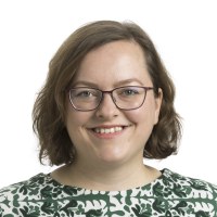 Saana Rossin kasvokuva. Hänellä on hymyilevä ilme, silmälasit ja ruskea polkkatukka.