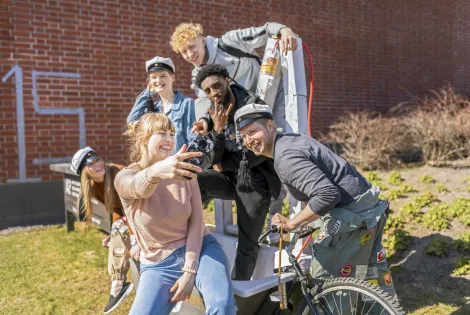 Opiskelijaporukka ottaa selfietä.