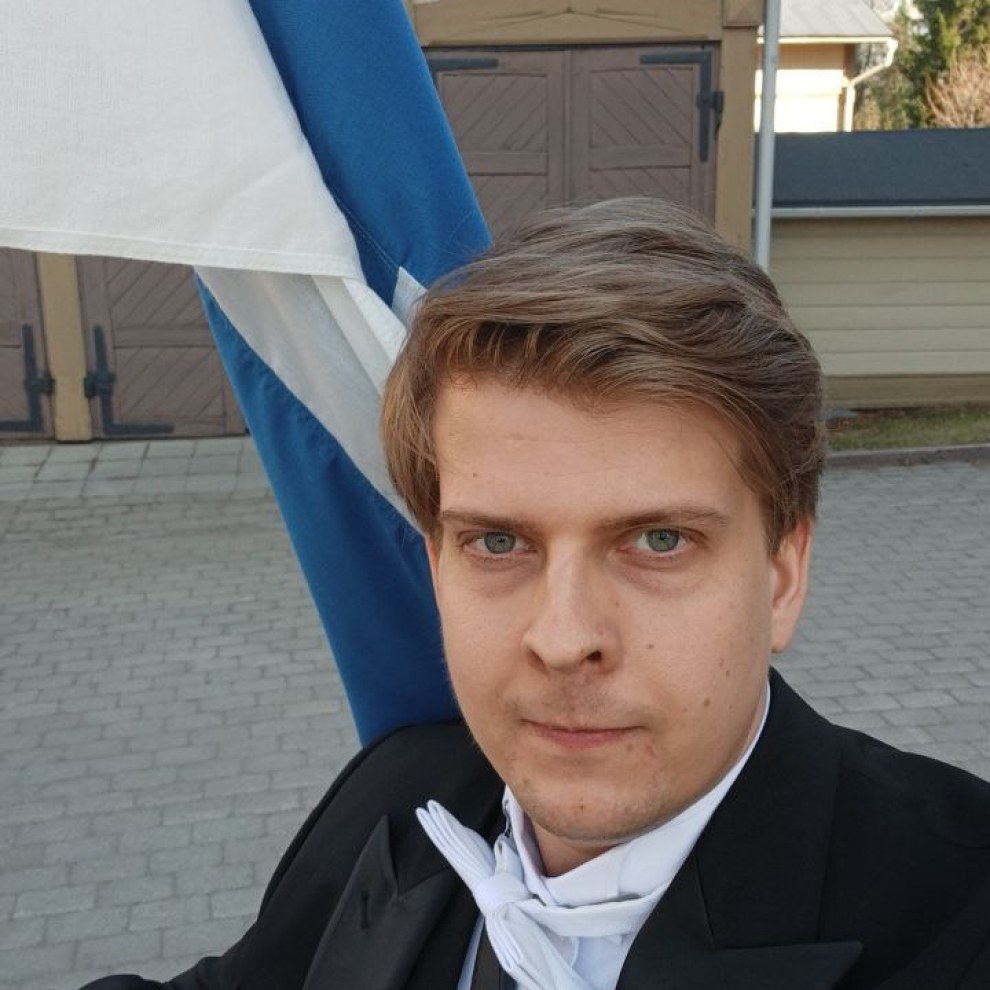 Kuva minusta tohtoripromootiossa Suomen lipun kanssa