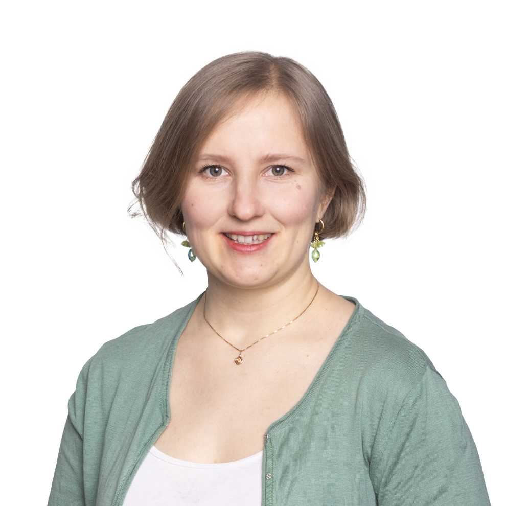 Nuori lyhyttukkainen nainen hymyilee aurinkoisesti vihreässä neuletakissa