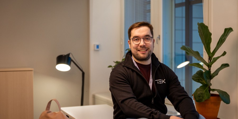Owain Hopeaketo istuu toimiston pöydän kulmalla.